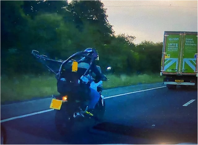 The biker was spotted travelling on the M18 with a motorbike framed strapped to his back.