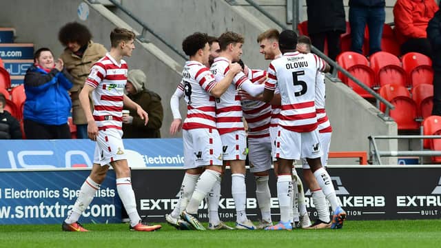 Doncaster's players celebrate George Miller's goal.