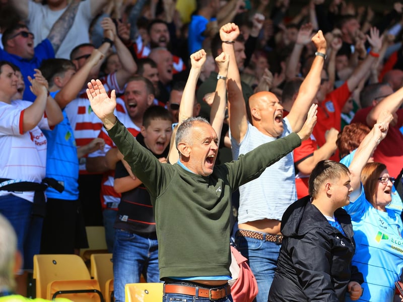 Doncaster Rovers fans celebrate as the full-time whistle blows.