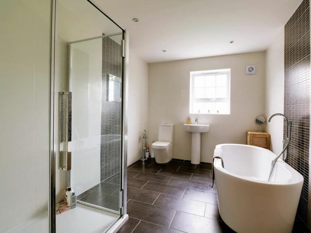 This bathroom has a free standing bath and a walk-in shower within its suite.