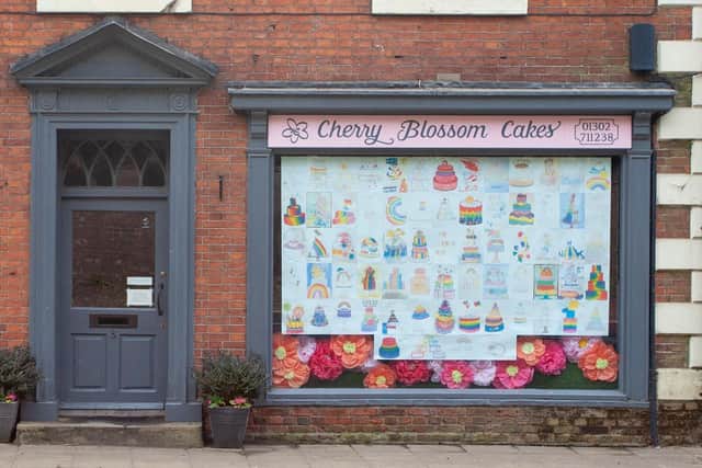 Rainbow cake display in shop front.