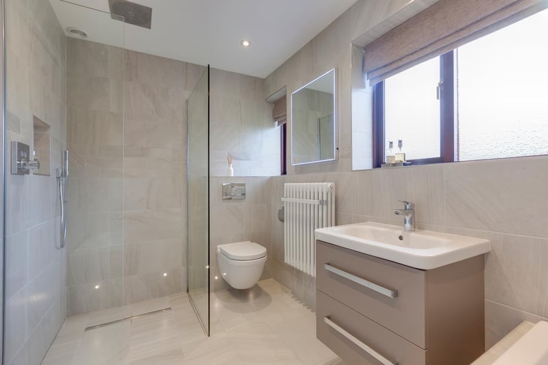 The modern family bathroom is fully tiled and has a suite in white by Duravit. To one corner, there’s a wet room style shower.