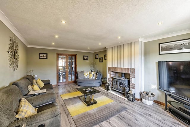 The spacious lounge with feature fireplace and wood-burning stove.