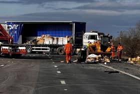 Workmen continuing on the site of the four vehicle crash which closed the M180 near Thorne, Doncaster, last night, and has remained closed on one carriageway today