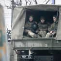 Ukrainian soldiers ride in a military vehicle in Mariupol, Ukraine, Thursday, Feb. 24, 2022. Russian troops launched their anticipated attack on Ukraine on Thursday, as President Vladimir Putin cast aside international condemnation and sanctions, warning other countries that any attempt to interfere would lead to "consequences you have never seen." (AP Photo/Sergei Grits)