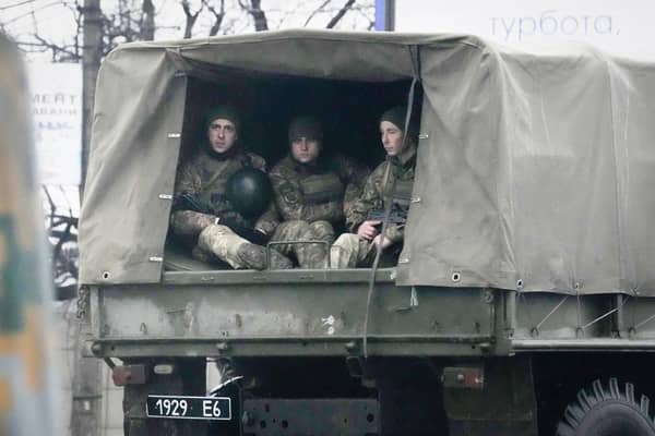 Ukrainian soldiers ride in a military vehicle in Mariupol, Ukraine, Thursday, Feb. 24, 2022. Russian troops launched their anticipated attack on Ukraine on Thursday, as President Vladimir Putin cast aside international condemnation and sanctions, warning other countries that any attempt to interfere would lead to "consequences you have never seen." (AP Photo/Sergei Grits)