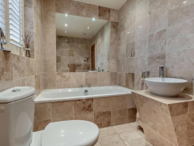A modern, fully tiled bathroom.