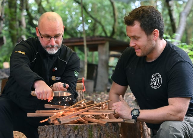 Nathan Pritchard (Flooring Superstore) lighting a campfire under the guidance of Nick Goldsmith, who runs Hidden Valley Bushcraft