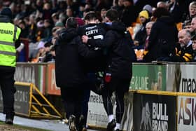 Connor Carty is carried off after injuring his knee after slipping on the edge of the pitch at Bradford.