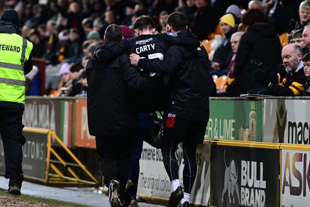 Connor Carty is carried off after injuring his knee after slipping on the edge of the pitch at Bradford.