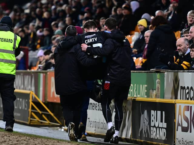 Connor Carty is carried off after injuring his knee after slipping on the edge of the pitch at Bradford.