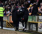 Connor Carty is carried off after injuring his knee after slipping on the edge of the pitch at Bradford.