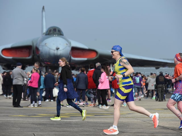 Runners pass the Vulcan bomber as they approach the finish of the 5.8k race.