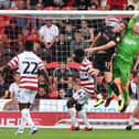 Doncaster's Johnny Mitchell catches under pressure against Salford City.