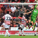 Doncaster's Johnny Mitchell catches under pressure against Salford City.