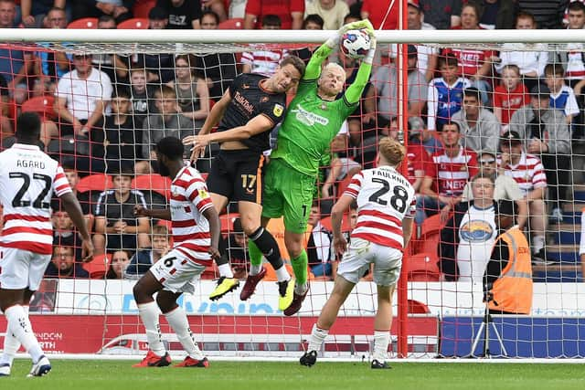 Doncaster's Johnny Mitchell catches under pressure against Salford City.