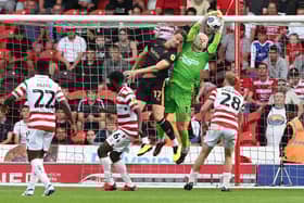Doncaster's Johnny Mitchell catches under pressure against Salford City.