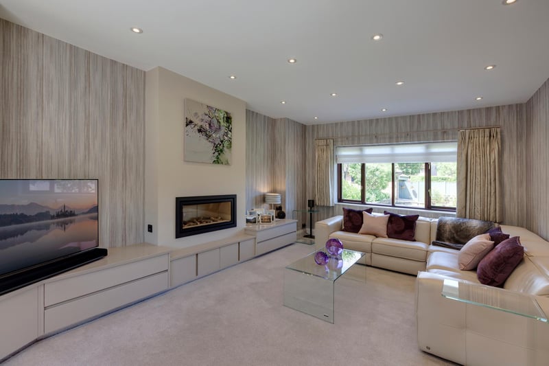 The lounge is described as a well-proportioned reception room with a front facing timber double glazed bay window. The focal point of the room is the remote controlled Gazco gas fire.