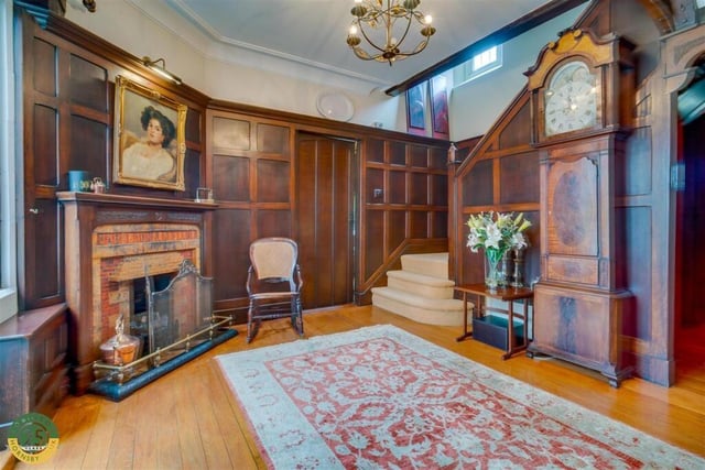 An impressive panelled hallway with fireplace.