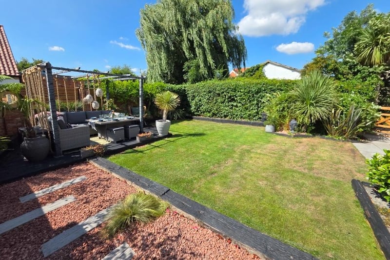 A section of lawned garden with seating area.