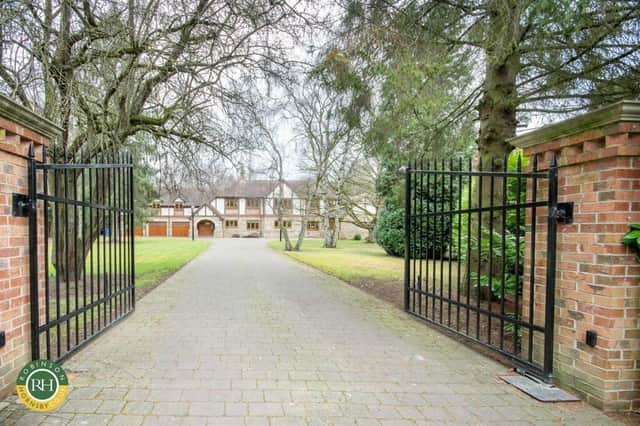 The tree-lined driveway that leads up to the impressive frontage of the house with triple garage.