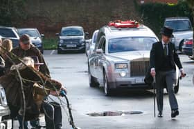 The funeral car makes its way to the chuch.