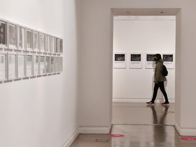 A visitor at Hal Fischer: Gay Semiotics and other major works in Gallery 3 (b&w photo exhibition).