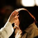 A worshipper receives a cross of ashes painted on her forehead during an Ash Wednesday service at the start of Lent