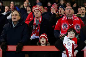 ACCRINGTON, ENGLAND - JANUARY 24: Accrington Stanley fans watch on from the terrace with a tin foil FA Cup trophy during the Emirates FA Cup Third Round Replay between Accrington Stanley and Boreham Wood at Wham Stadium on January 24, 2023 in Accrington, England. (Photo by George Wood/Getty Images)