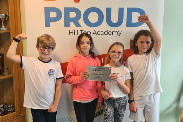 Celebrating success are (from left) Caleb (8), Czenga (9), Scarlett (9) and Hector (9) with the plaque the school received for being chosen as district winners