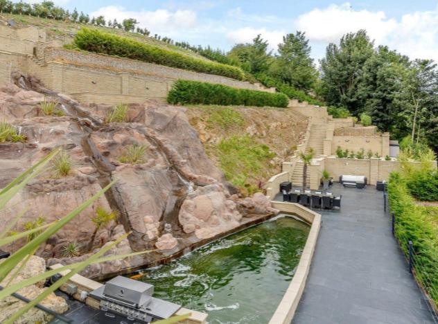The outdoor seating and BBQ area is ideal for al fresco dining, and sits adjacent to the impressive waterfall-effect fountain.