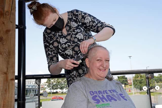 Karen Lovell, pictured having her head shaved by daughter Naomi. Picture: NDFP-20-07-21-Lovell 3-NMSY