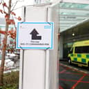 A sign directs patients towards an NHS 111 Coronavirus Pod (Photo by ISABEL INFANTES/AFP via Getty Images)