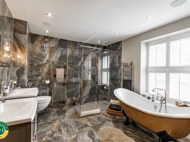 This stunning bathroom has twin wash basins with a free standing bath and a walk-in shower.