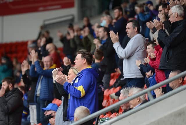 Dons fans welcome the players onto the pitch. Photo: Rob Terrace