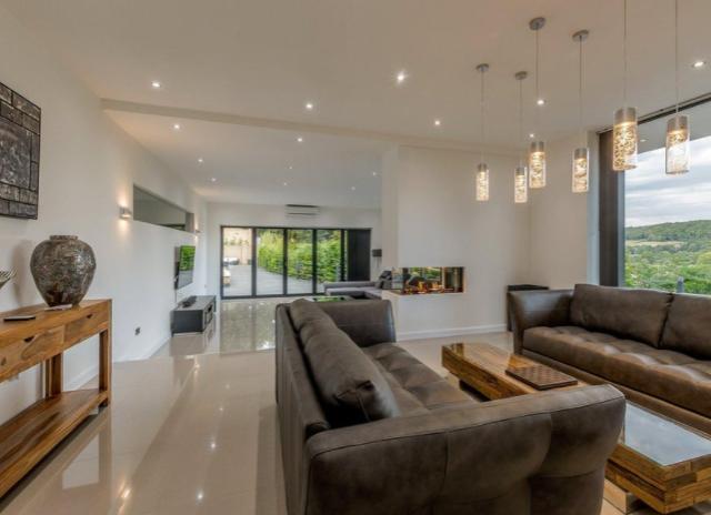 The sitting room opens out onto the family room, which encompasses a comfy sitting area to relax in and stunning views across the landscape.