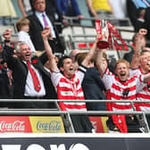 Rovers skipper Brian Stock lifts the play-off trophy with Adam Lockwood.