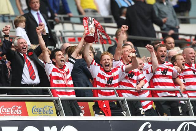 Rovers skipper Brian Stock lifts the play-off trophy with Adam Lockwood.