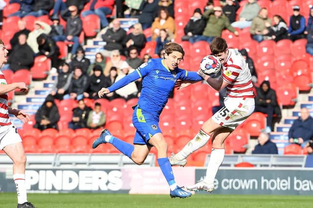 Doncaster's Adam Long wins a header against Grimsby.