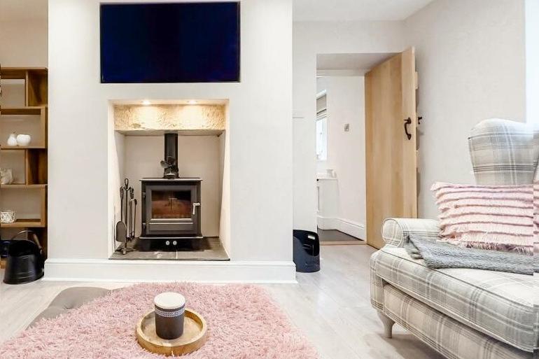 A cosy stove within a fireplace feature is a focal point within the living room.