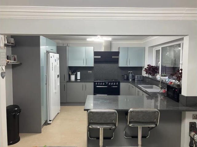 A sleek and modern fitted kitchen with breakfast bar.
