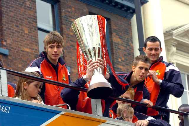Rovers players display the Johnstone's Paints Trophy on the open top bus.