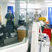 Medical staff wearing full PPE (personal protective equipment), including a face mask, long aprons, and gloves as a precautionary measure against COVID-19, work on an Intensive Care Unit (ICU) ward. Photo by STEVE PARSONS/POOL/AFP via Getty Images