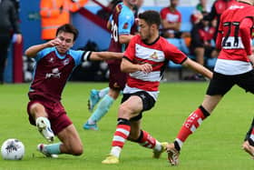 Doncaster Rovers' Tommy Rowe battles for the ball with Scunthorpe United's Michael Clunan.