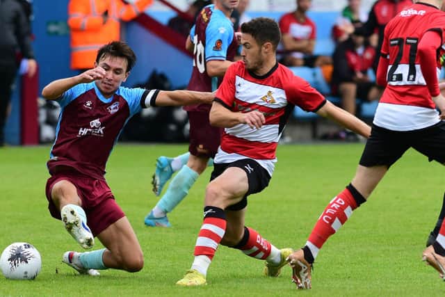 Doncaster Rovers' Tommy Rowe battles for the ball with Scunthorpe United's Michael Clunan.