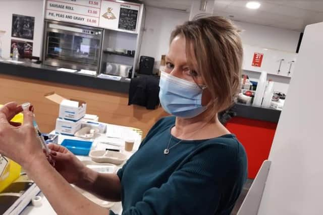 A volunteer prepares a dose of vaccine at the Keepmoat Stadium vaccination centre