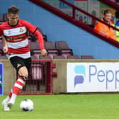 Doncaster Rovers' George Broadbent looks to pass the ball against Scunthorpe United.