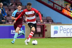 Doncaster Rovers' George Broadbent looks to pass the ball against Scunthorpe United.