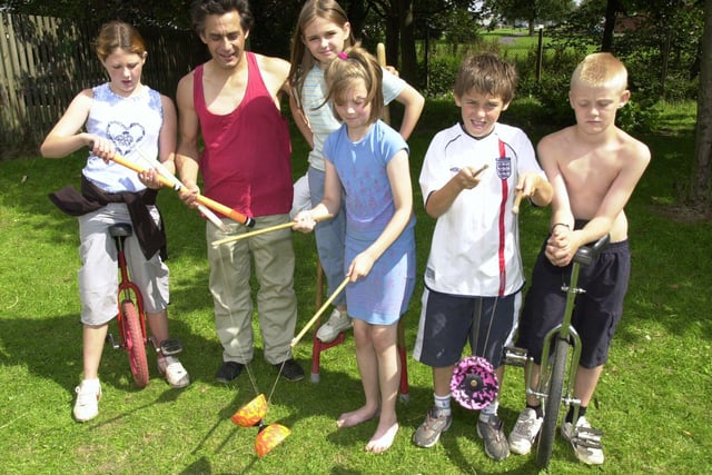 Children trying out the Green Top Community Circus activities at the Batemoor and Jordanthorpe Community Centre, Dyche Lane, Sheffield in August 2002. Pictured left to right are Abbey Parry, Richard Gillett from Green Top, Leigh Major, Haley Smith, Justin Smith and Marcus Russell