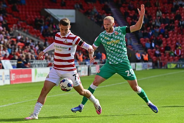 Doncaster's Luke Molyneux fends off Swindon's Frazer Blake-Tracy.